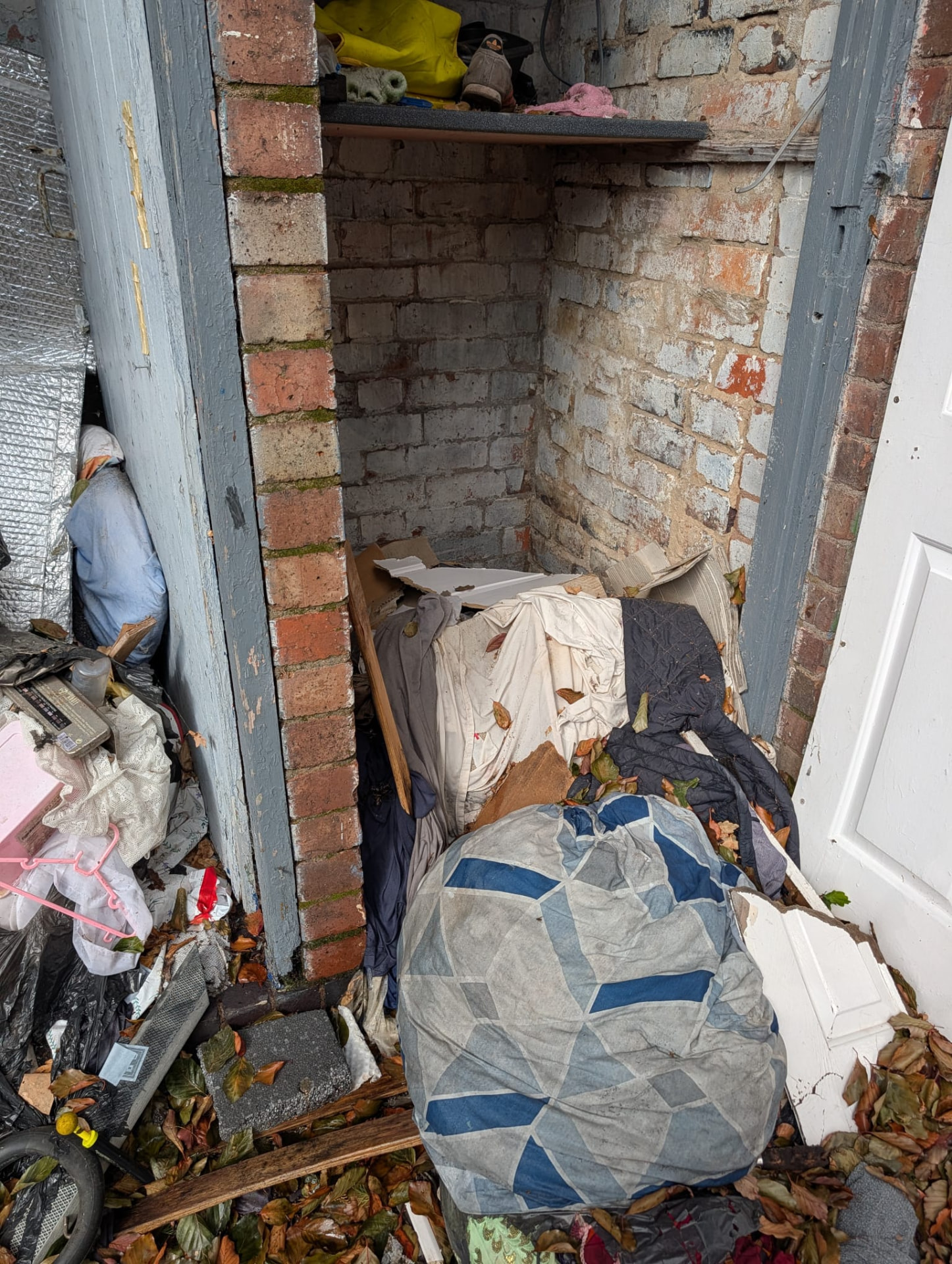 Before: outbuilding filled with bags and bedding
