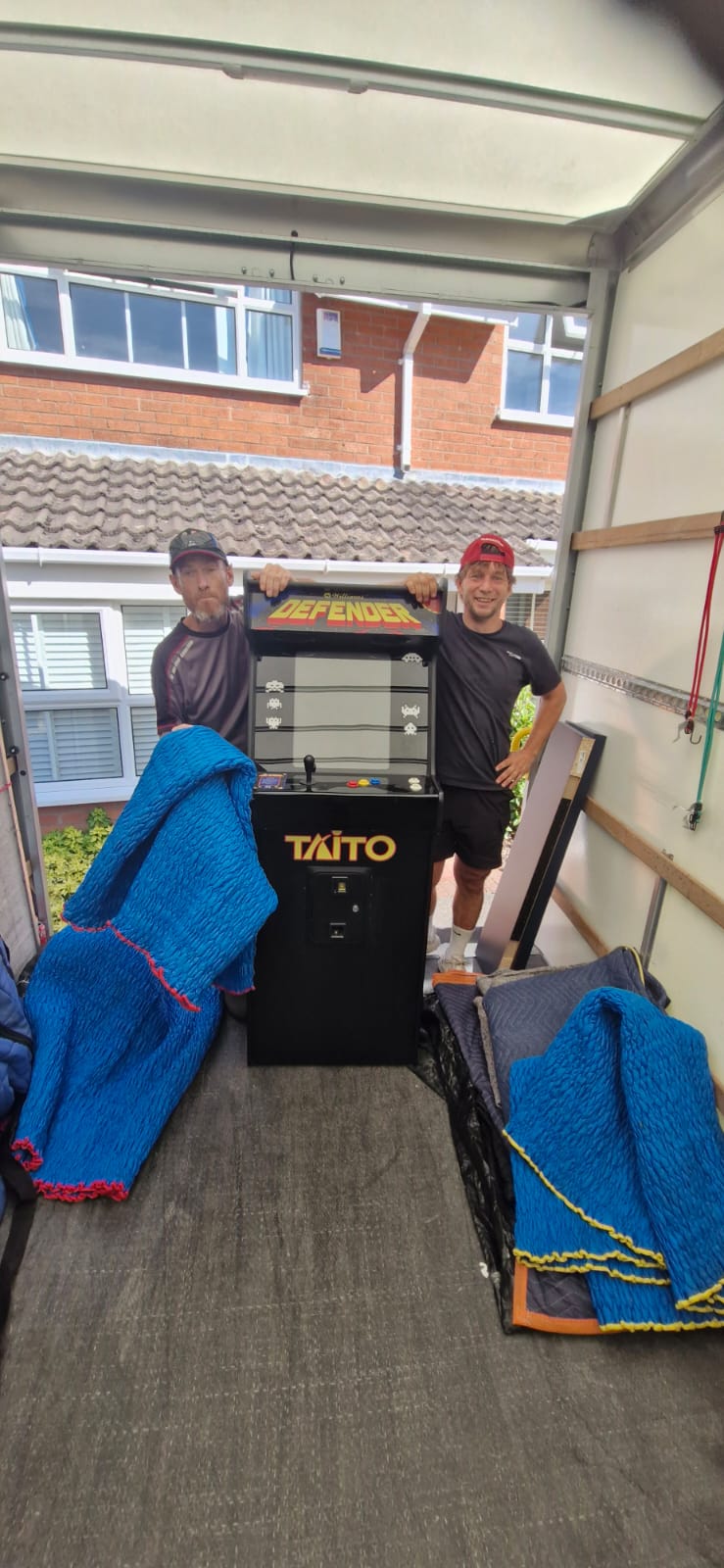 Shaw Haul crew loading an arcade machine into the Luton with padded blankets