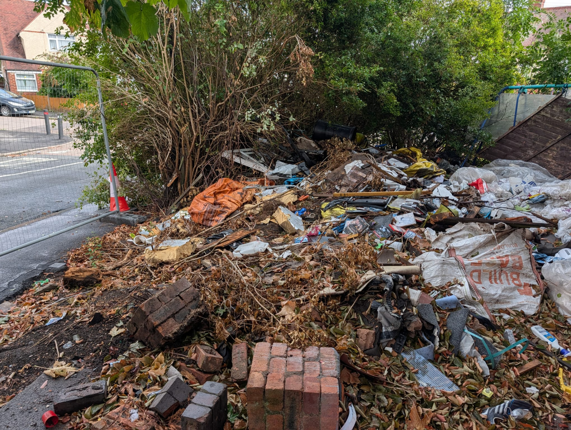Before: large waste pile beside a fenced street frontage