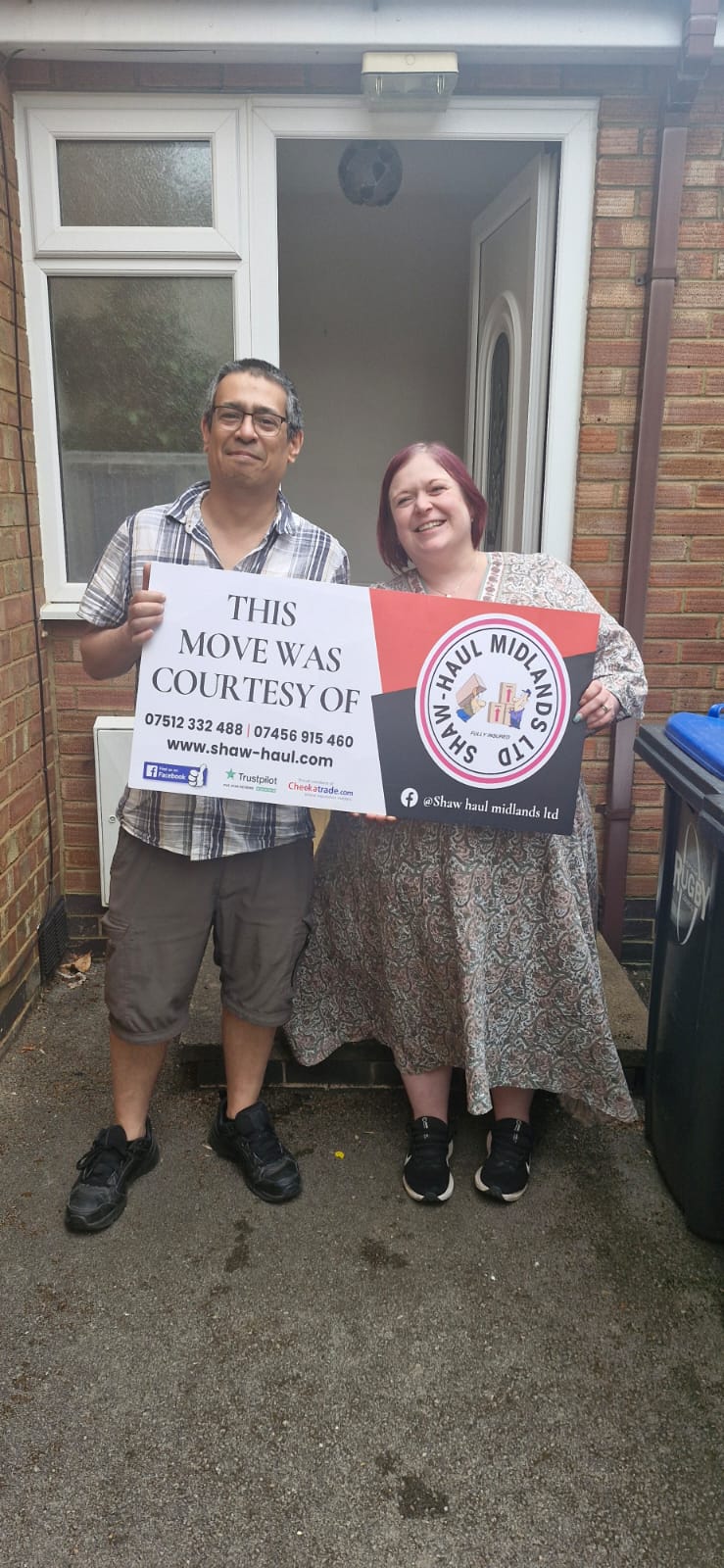 Smiling customers holding the "This move was courtesy of" sign