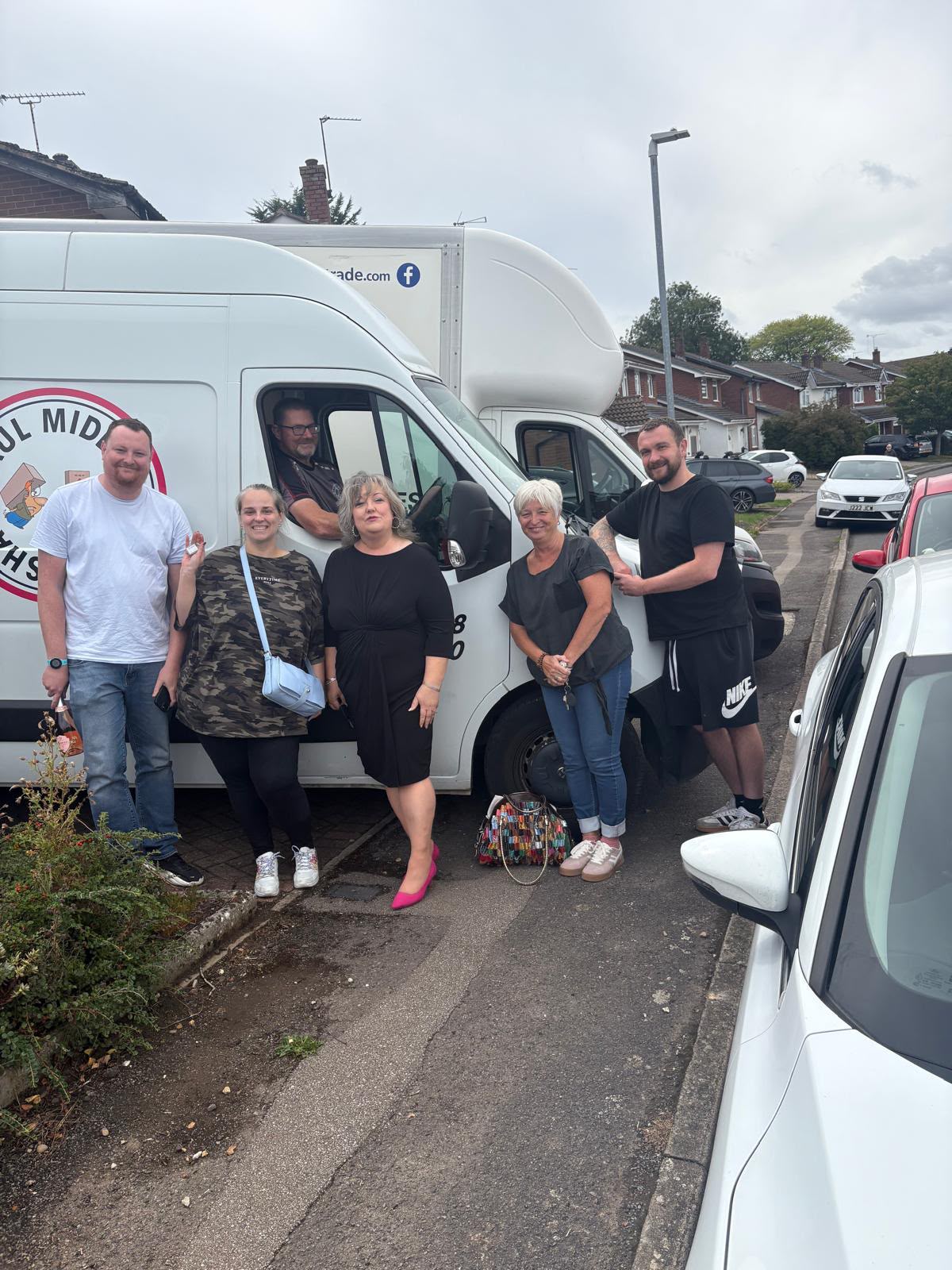 Group of happy customers by the Shaw Haul van with the driver waving