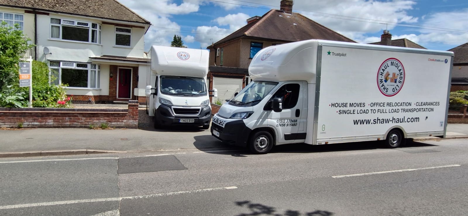 Two Shaw Haul Luton vans outside a sold home