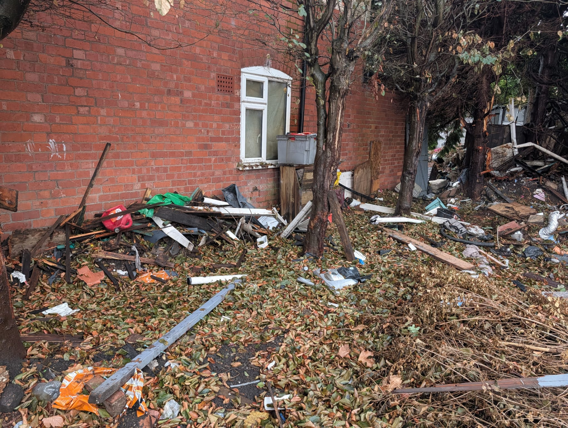Before: timber and debris against a brick wall