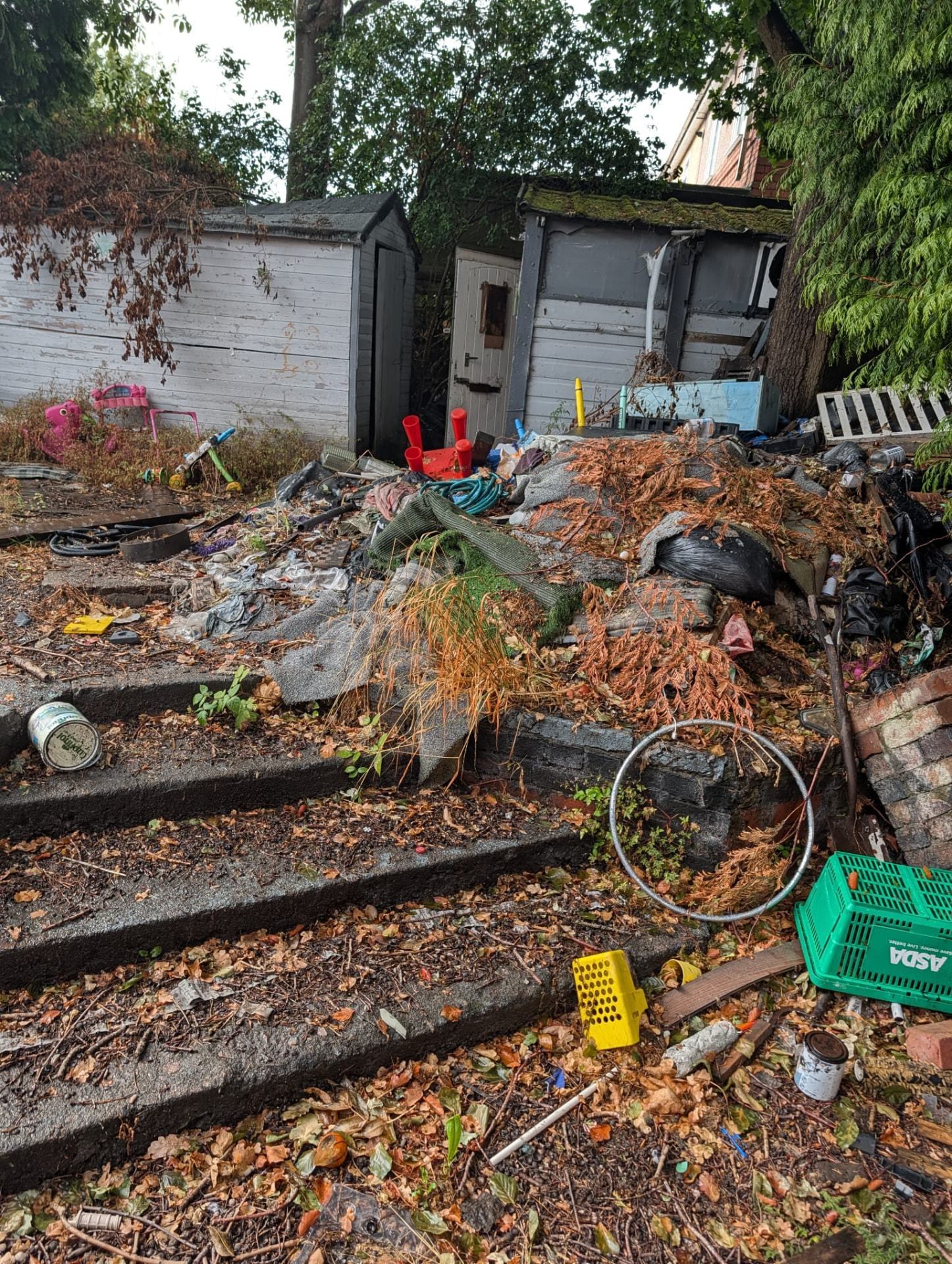 Before: garden sheds buried in waste