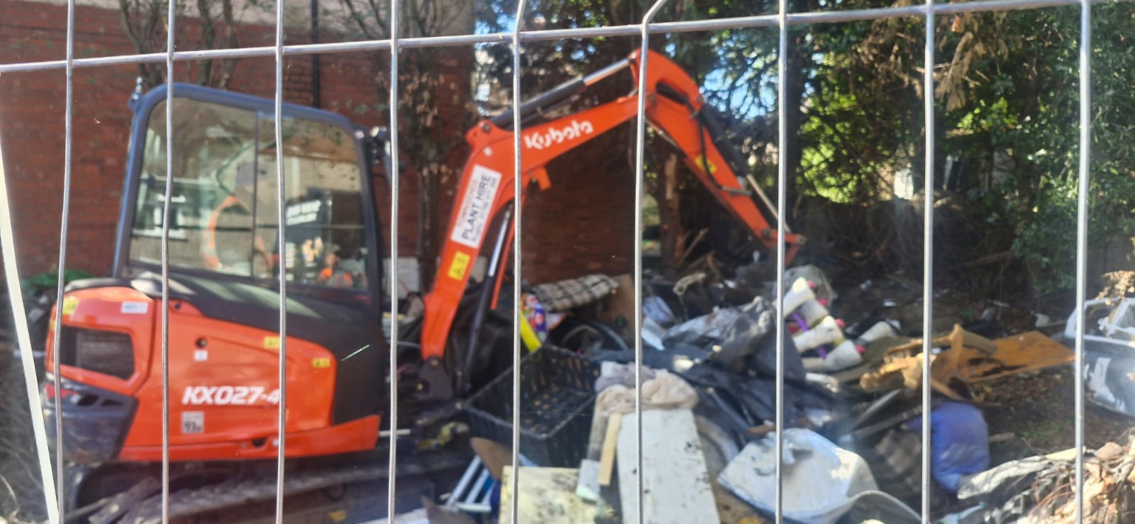 In progress: waste being cleared behind site fencing