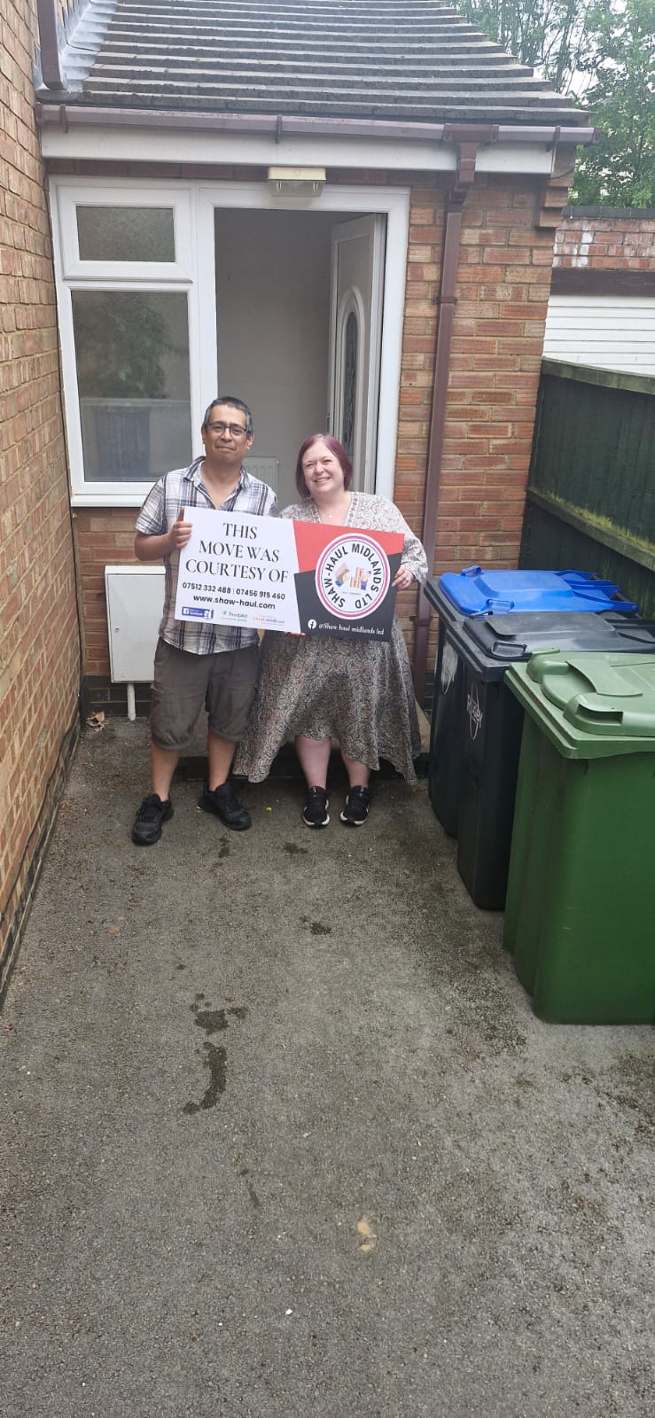 Customers with a Shaw Haul sign outside their new front door