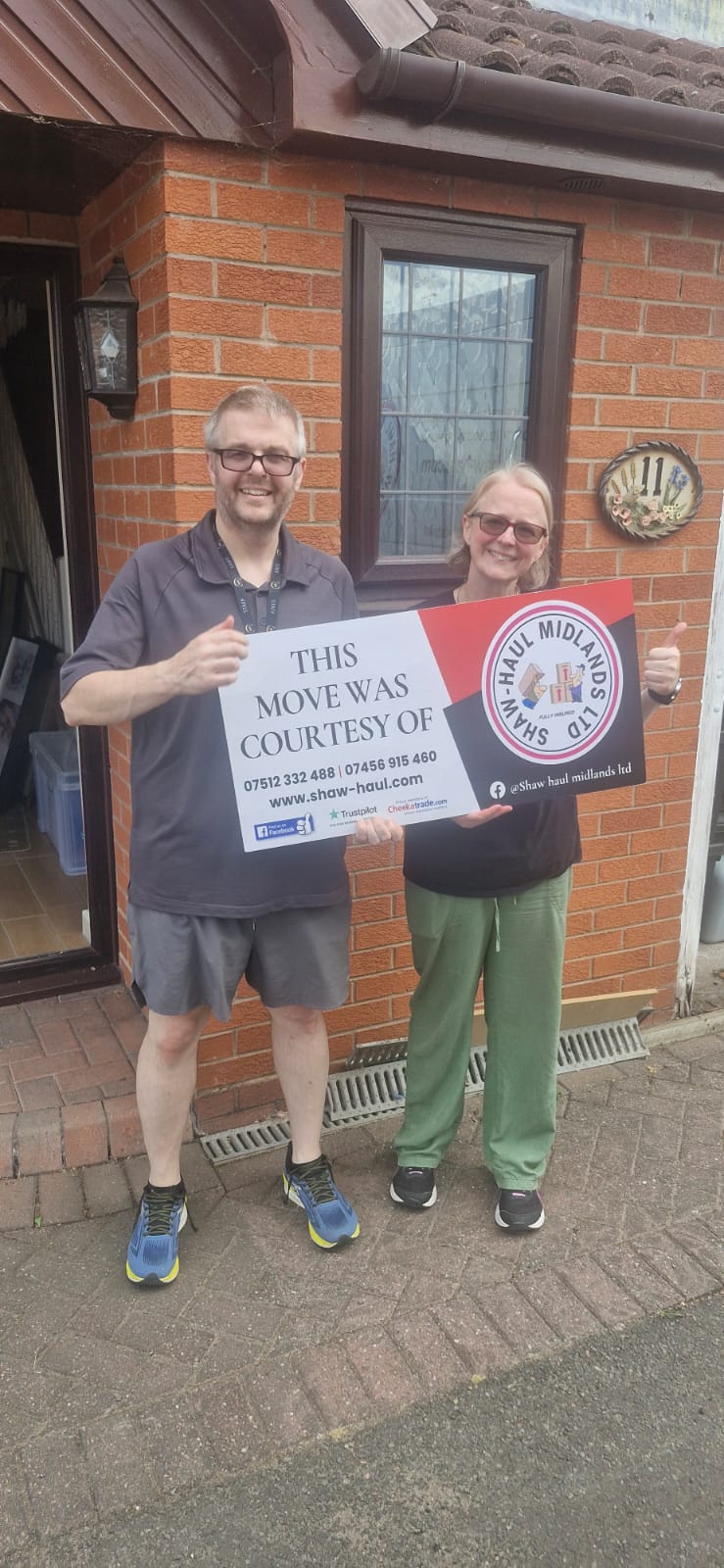 Couple celebrating their move with a Shaw Haul sign