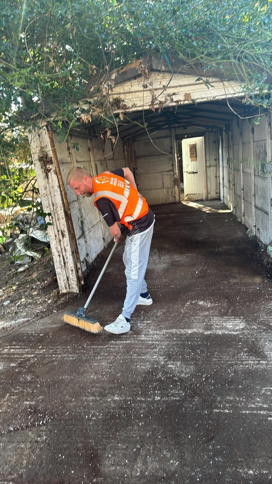 Sweeping out a garage once the clearance is complete.